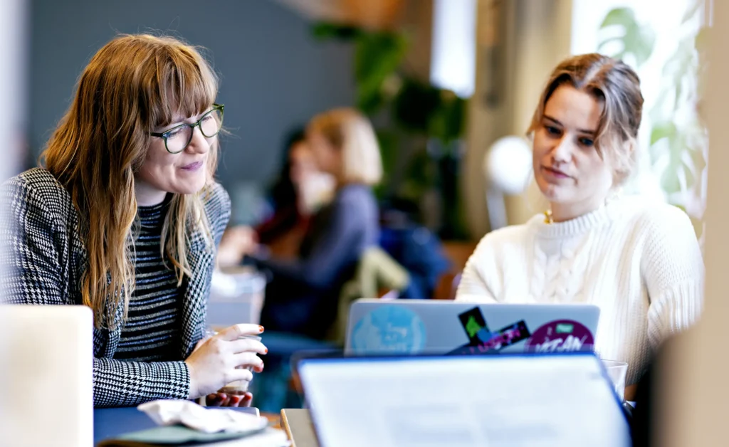 Two people looking at a screen in the Coworking Café area